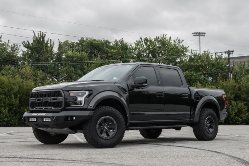The black Road Armor 17-20 Ford Raptor Stealth Front Non-Winch Bumper - Tex Blk is parked in a parking lot.