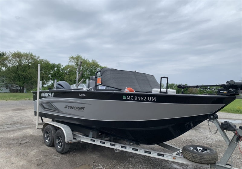 Boat with Truxedo Boat Windshield Protector mounted on a trailer in a parking area