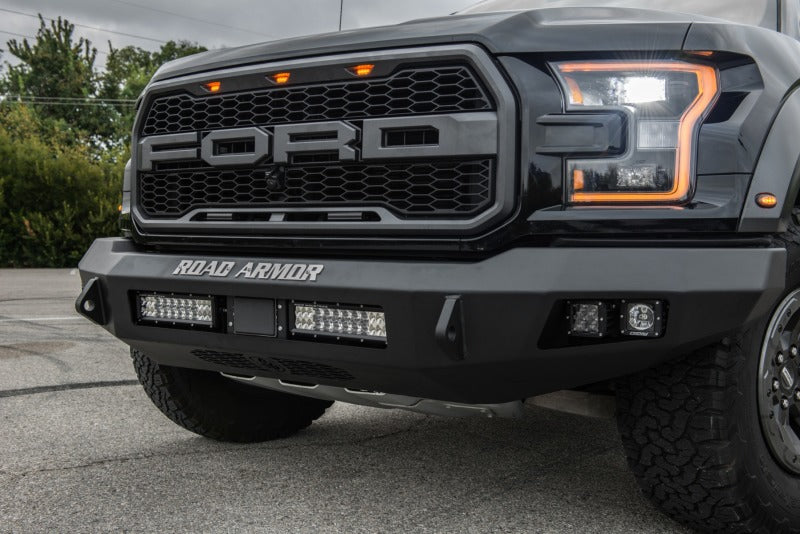 The front of a black Road Armor Ford Raptor truck.
